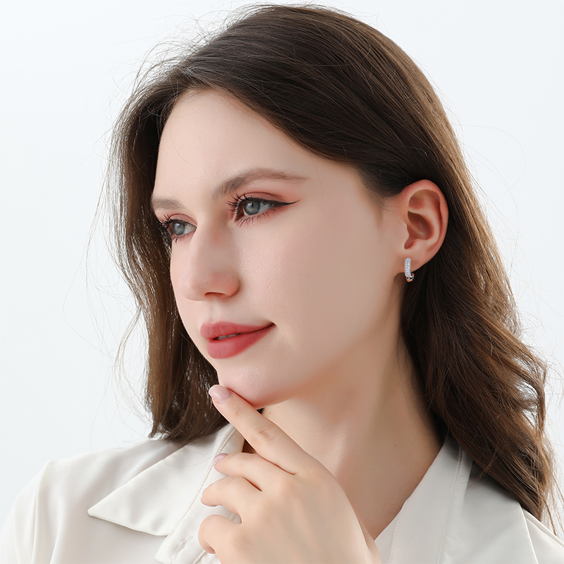 Round Brilliant Moissanite U-Hoop Earrings worn on a model, showing the earring scale and fit on the ear